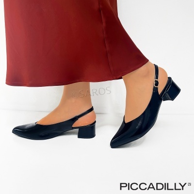 Sapatilhas pretas verniz de salto baixo com tira ajustável, num fundo branco.