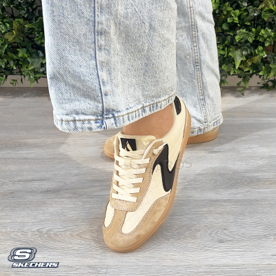 Ténis Skechers bege e castanho claro com detalhe preto, usados com calças de ganga
