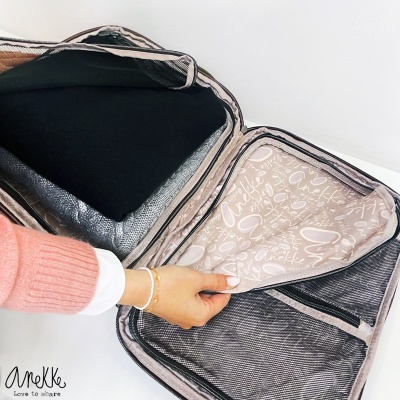 Mala de viagem aberta com roupas e bolso interno com padrão de texto Anekke