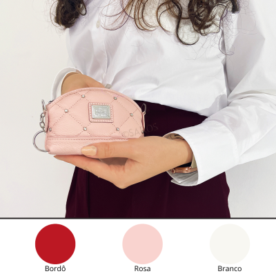 Carteira rosa com cristais em pele sintética segurada por mão feminina