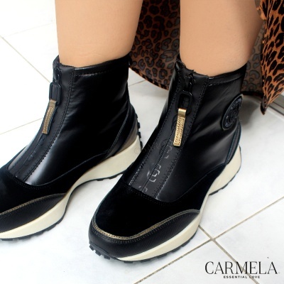 Botas pretas com fecho de correr frontal e sola branca em pavimento de azulejo
