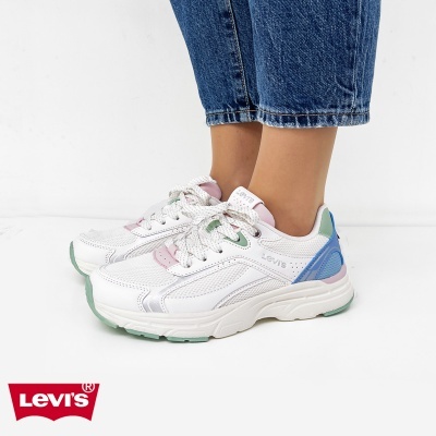 Ténis Levis brancos com detalhes coloridos e calças de ganga azuis