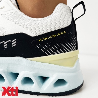 Ténis desportivos brancos e pretos com texto XTI THE URBAN BRAND