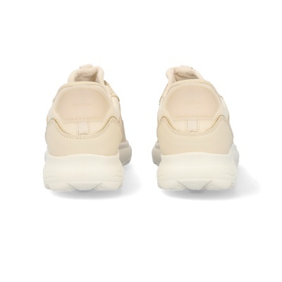 Tênis bege claro e creme com sola branca vistos de trás