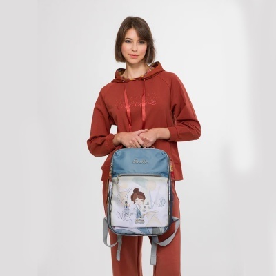 Mochila azul celeste com bolso frontal ilustrado e mulher com fato desportivo vermelho tijolo