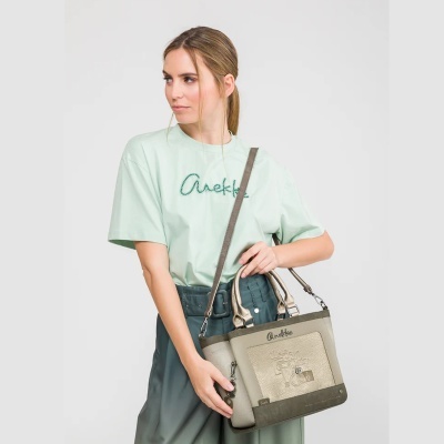 Mulher com mala bege e verde e t-shirt verde claro