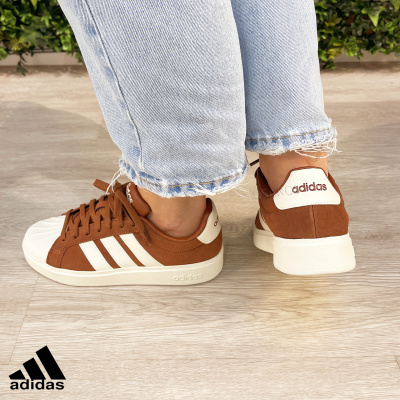 Ténis castanhos Adidas com riscas brancas e sola branca