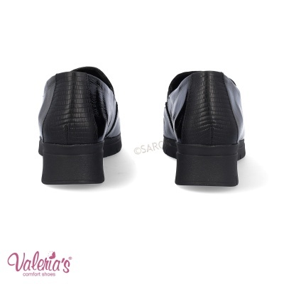 Sapatos pretos de senhora com textura de pele e salto baixo vistos de trás