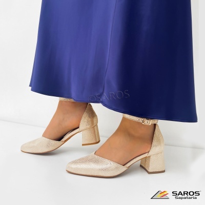 Sapatos bege com salto médio e fecho no tornozelo usados com vestido azul escuro