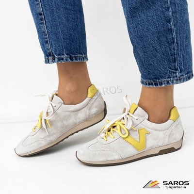 Sapatilhas cinza clara com detalhes amarelos usadas com jeans azuis