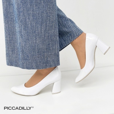 Sapatos de salto alto brancos brilhantes com calças azuis