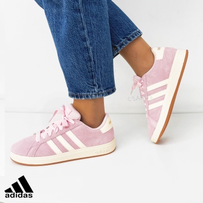Ténis Adidas rosa com riscas brancas e sola castanha usados com jeans azuis