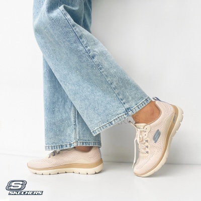 Ténis rosa claro Skechers com sola bege e detalhes azuis usados com calças de ganga azul claro com cristais