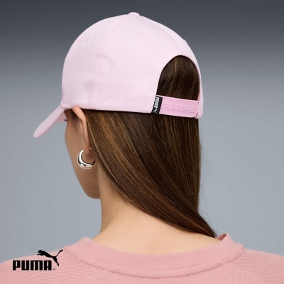Boné rosa claro com etiqueta PUMA e fecho ajustável, visto de trás em pessoa de cabelo castanho