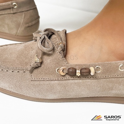Mocassins de camurça bege com contas de madeira e metálicas, atacadores decorativos e sola castanha.