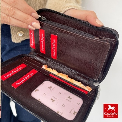 Carteira preta de couro com compartimentos para cartões e fecho de correr