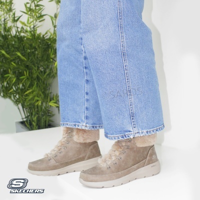 Botas femininas bege de camurça com pelo e sola clara, usadas com calças de ganga azul