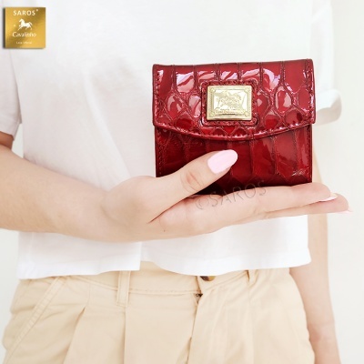 Carteira vinho texturizada com placa dourada na mão de pessoa com camisa branca