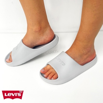 Chinelos Levis cinzentos com logo em relevo numa superfície branca