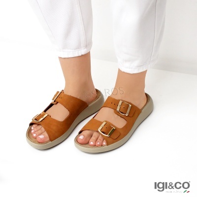 Sandálias castanhas com fivelas douradas e solado cinzento usadas com calças brancas