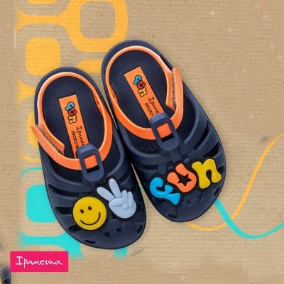 Sandálias azuis e laranja para criança com aplicações coloridas e smiley amarelo