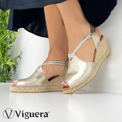 Sandálias de cunha douradas metálicas em modelo feminino