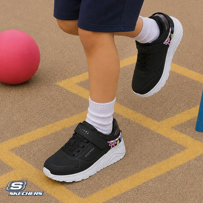 Tênis infantis Skechers preto com sola branca e detalhes coloridos, usados por uma criança em parque com bola rosa