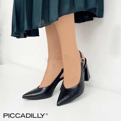 Sapatos de salto alto pretos com padrão crocodilo usados com vestido verde escuro