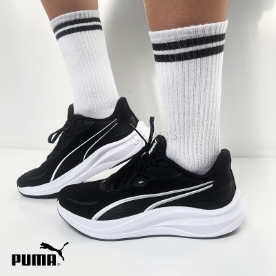 Ténis desportivos Puma pretos com sola branca e meias brancas com riscas pretas