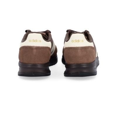 Ténis Adidas castanhos e bege vistos de trás com sola preta.
