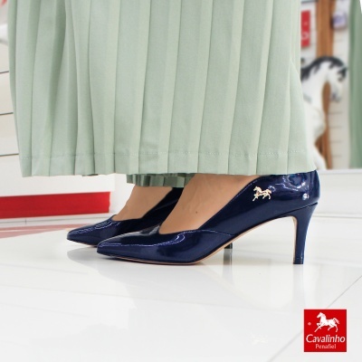 Sapatos de salto médio em verniz azul escuro com logótipo dourado de cavalo.