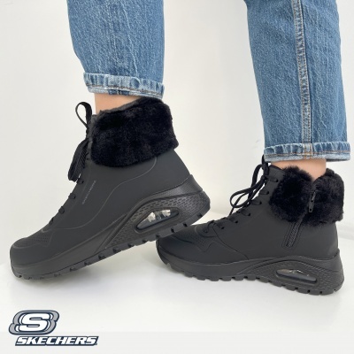 Botins Skechers pretos com pelúcia usada com jeans azuis