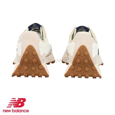 Par de ténis New Balance vistos por trás com sola castanha e parte superior branca e bege