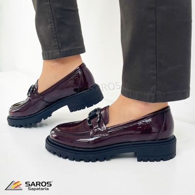 Mocassins vinho com sola preta grossa e detalhe metálico, usados com calças pretas