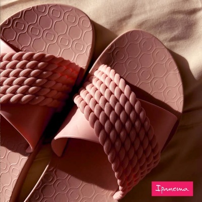 Chinelos cor de rosa com tira trançada e sola com padrão de círculos