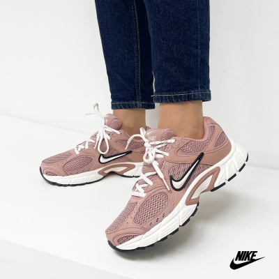 Ténis Nike rosa e branco com atacadores brancos em fundo branco