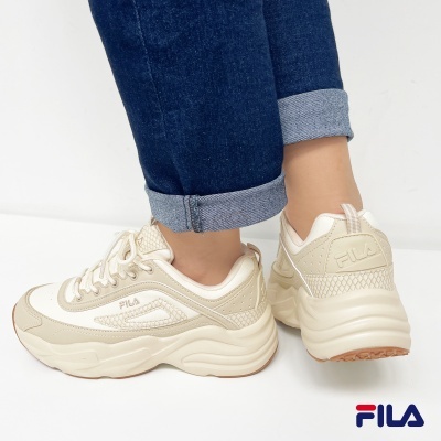 Ténis FILA bege e branco usados com calças de ganga azul