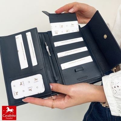 Carteira preta em pele com ranhuras e fecho dourado, etiquetas HANDMADE IN PORTUGAL e logo Cavalinho em fundo branco.