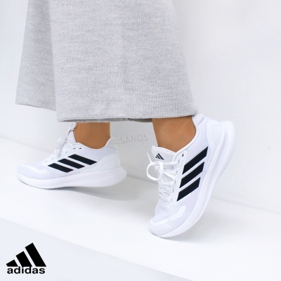 Ténis brancos Adidas com riscas pretas laterais