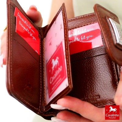 Carteira de couro castanha aberta mostrando compartimentos para cartões e a marca Cavalinho Penafiel