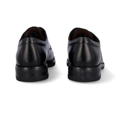 Par de sapatos sociais pretos em couro vistos de trás