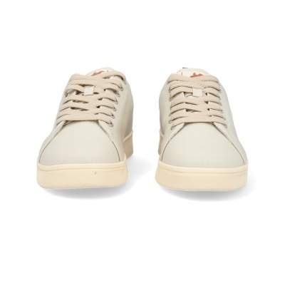 Ténis bege claro vistos de frente sobre fundo branco