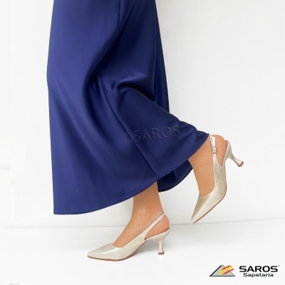 Sapatos de salto médio dourados com saia azul