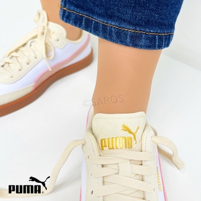 Ténis PUMA creme com detalhes rosa e amarelo, sola castanha, usados com calças de ganga.