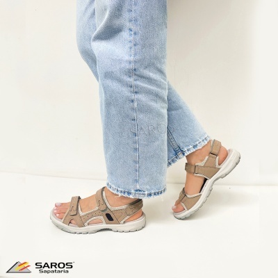 Sandálias castanhas claras com velcro e sola branca usadas com calças de ganga claras