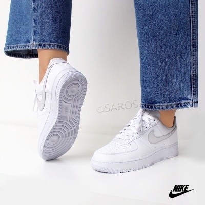 Sapatilhas Nike Air Force 1 brancas com detalhes cinza e jeans azuis