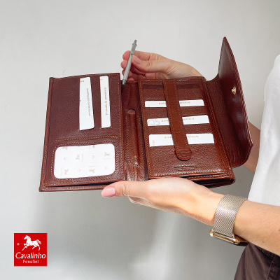 Carteira de couro castanho aberta com compartimentos para documentos e cartões