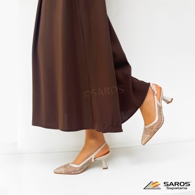 Sapatos bege com salto médio e design em rede usados com saia castanha.