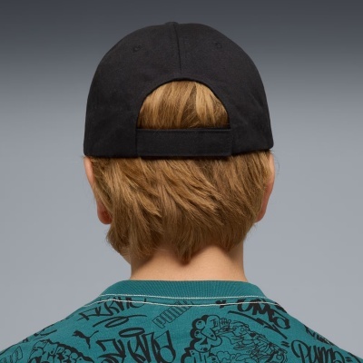 Pessoa de costas com boné preto e t-shirt azul com padrão grafite