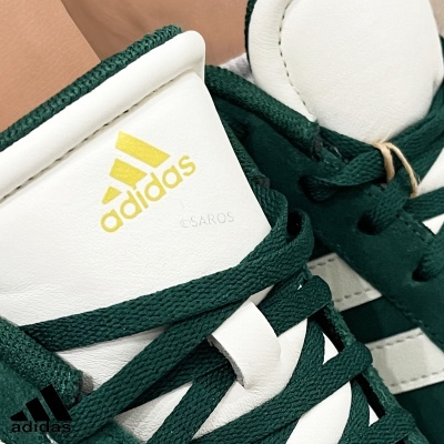Ténis Adidas branco e verde escuro com logo amarelo e atacadores verdes